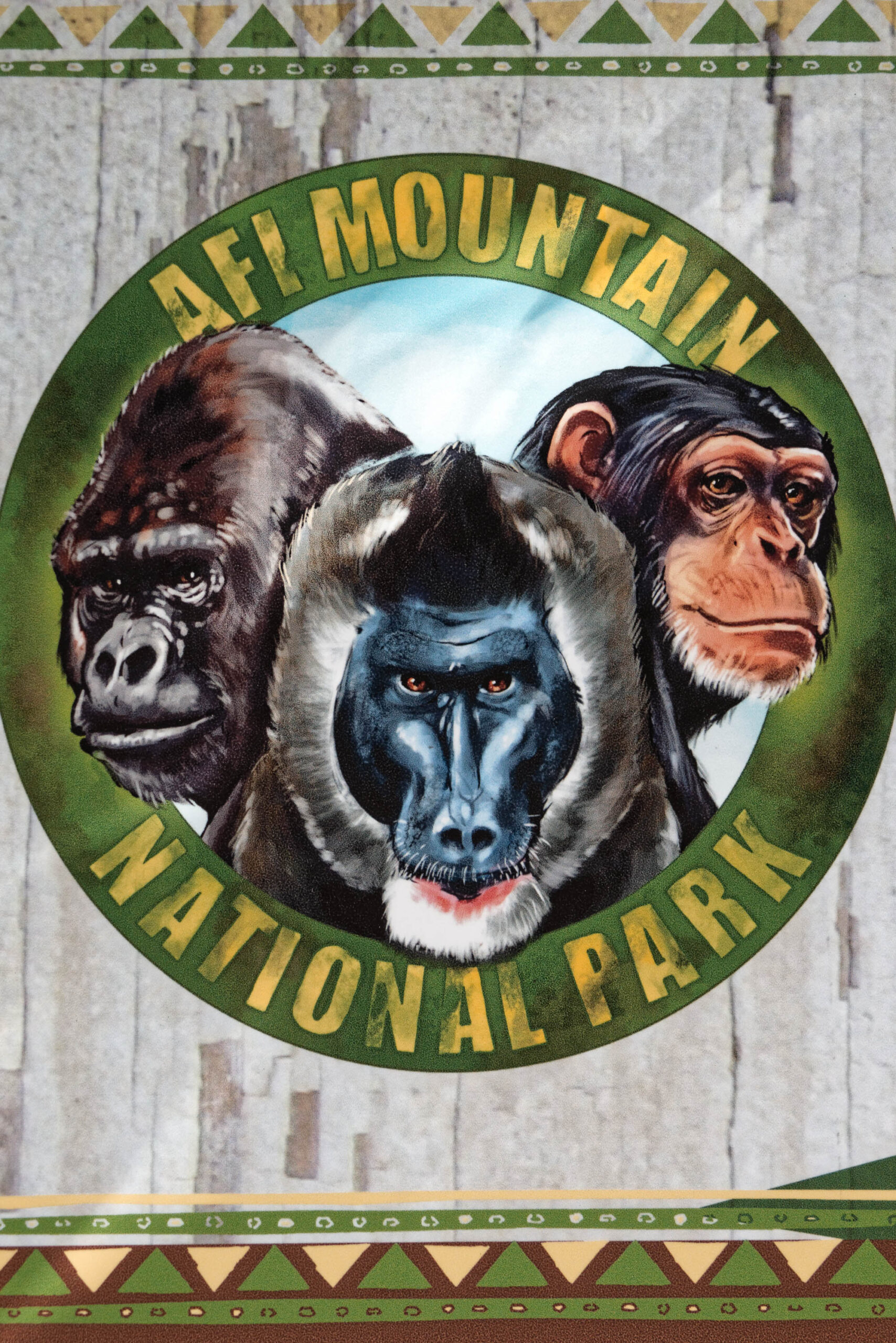 Das Bild zeigt eine stilisierte Darstellung von drei Affenköpfen, die in einem Kreis angeordnet sind. Die Affen sind in einem Comic-Stil gezeichnet und haben unterschiedliche Gesichtsausdrücke. Der Hintergrund ist ein Kreis mit dem Text 'NATIONAL PARK' und 'AFM MOUNTAIN'. Es handelt sich um eine Illustration, wahrscheinlich für den Erlebniszoo Hannover.