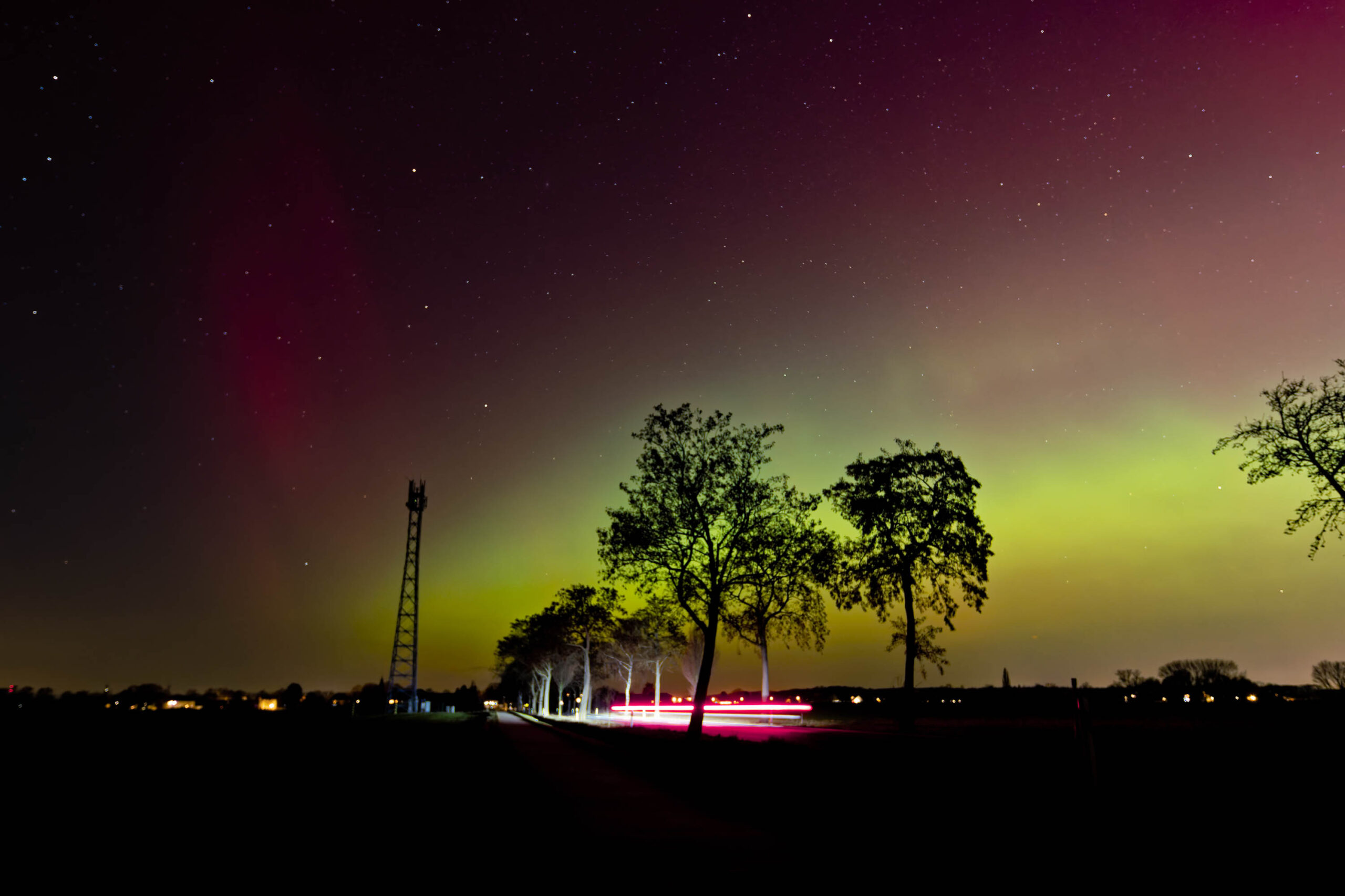 Ein atemberaubender Blick auf das Nordlicht, das über einem stillen See tanzt. Die Lichter färben den Himmel in leuchtenden Grüntönen und Violett.