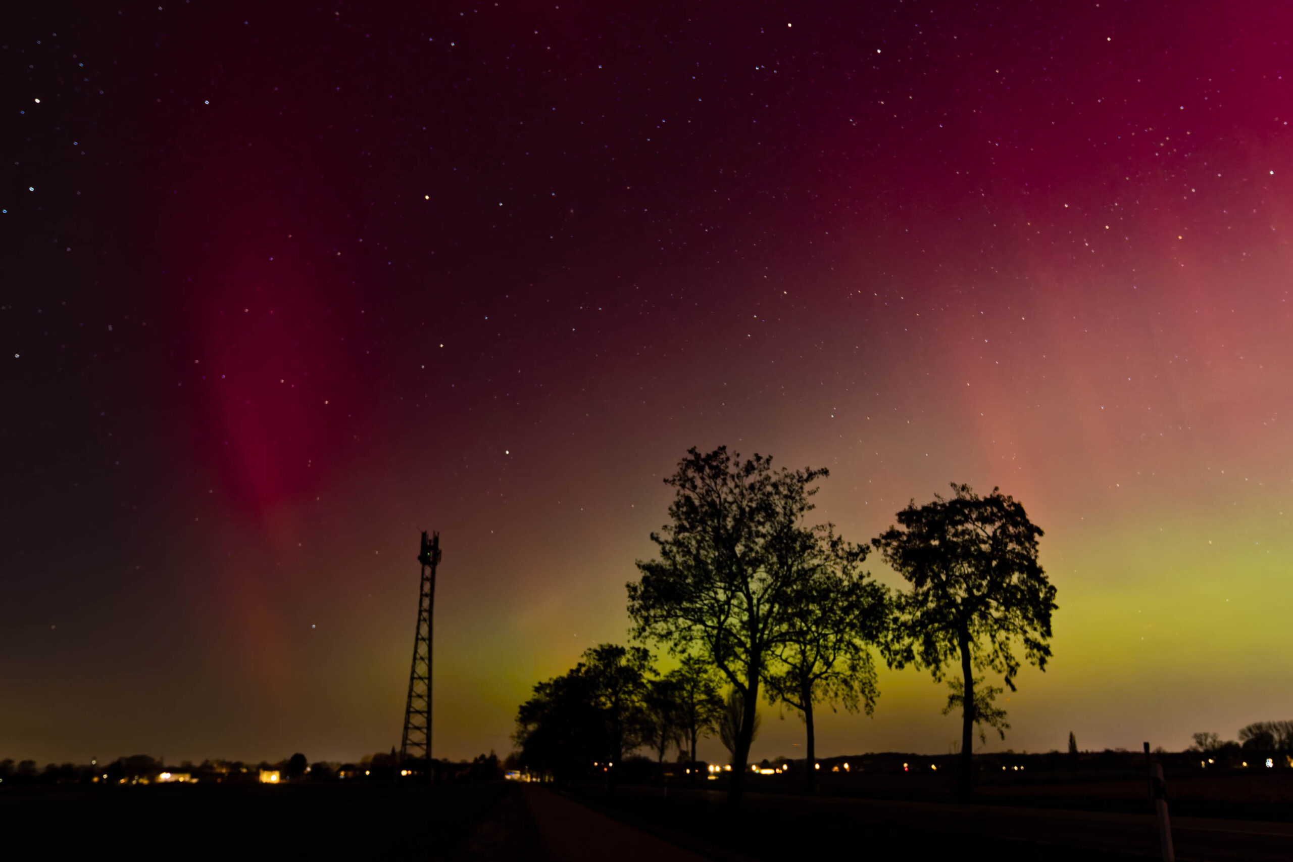 Ein atemberaubender Blick auf das Nordlicht, das über einem stillen See tanzt. Die Lichter färben den Himmel in grünen und violetten Tönen.