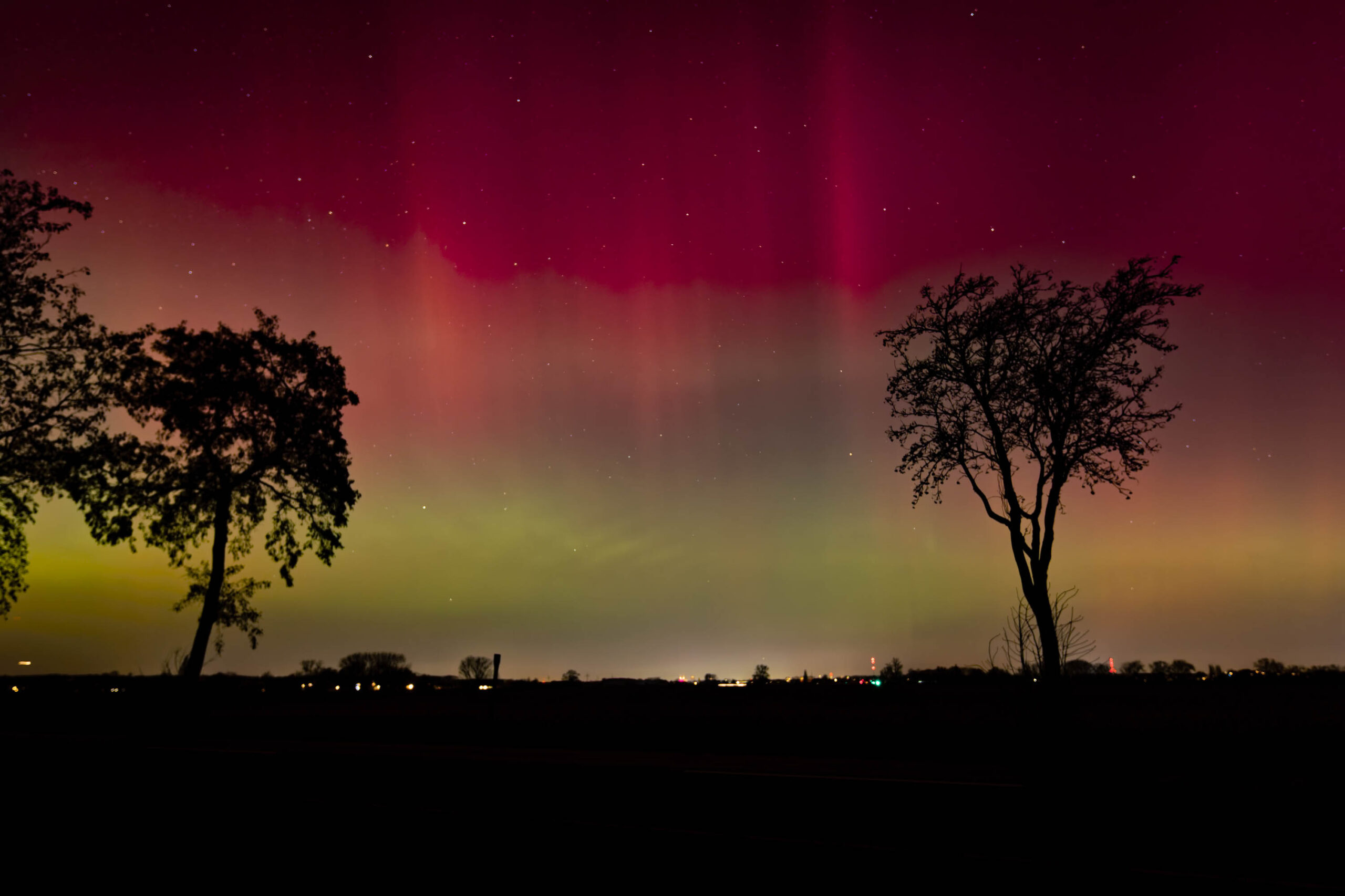 Ein atemberaubender Blick auf das Nordlicht, das über einem stillen See tanzt. Die Lichter färben den Himmel in Grün und Violett.